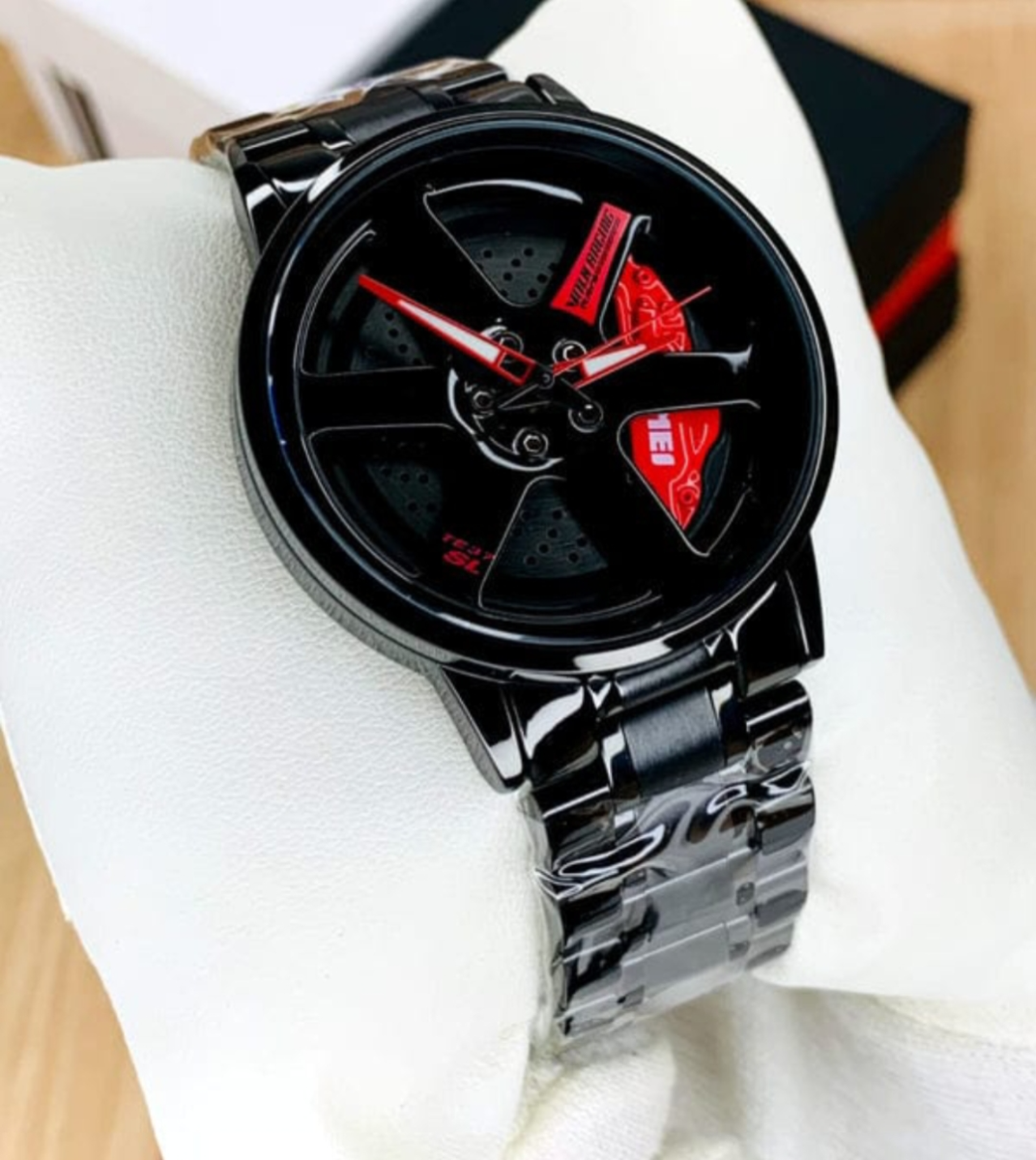 Car wheel watch with red caliper accent and all-black steel bracelet